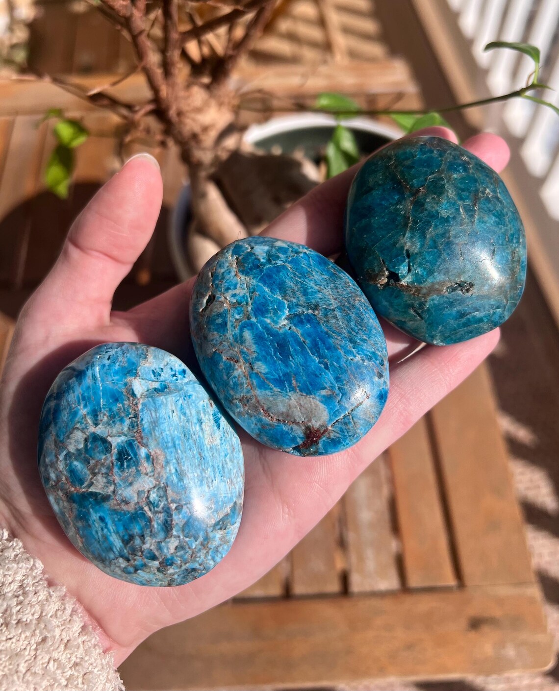 Blue Apatite palm stones: A at bottom left, B in the center, and C at top right